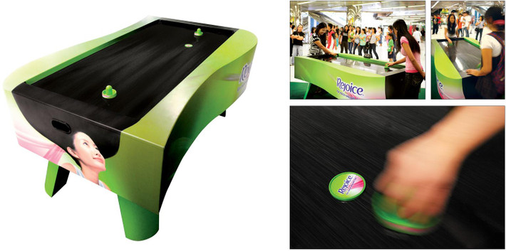 Bàn chơi game và hình ảnh mái tóc dùng dầu gội Rejoice siêu trơn trượt.