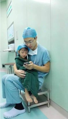 Bác sĩ dỗ bệnh nhân 2 tuổi có tên Shi Zhuo. Bác sĩ chuyên khoa tim này đang làm việc tại Bệnh viện Nhi thuộc trường Đại học Y tỉnh Chiết Giang, Trung Quốc. Trong ảnh, bác sĩ Zhuo chuẩn bị phẫu thuật cho bé gái 2 tuổi vào sáng 18/9.