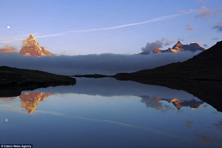 Mây và núi in bóng xuống mặt hồ phẳng lặng ở Zermatt, Thụy Sĩ.