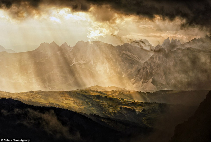 Những tia nắng ban mai chiếu xuống một ngôi làng ở vùng núi Dolomite, Italy.
