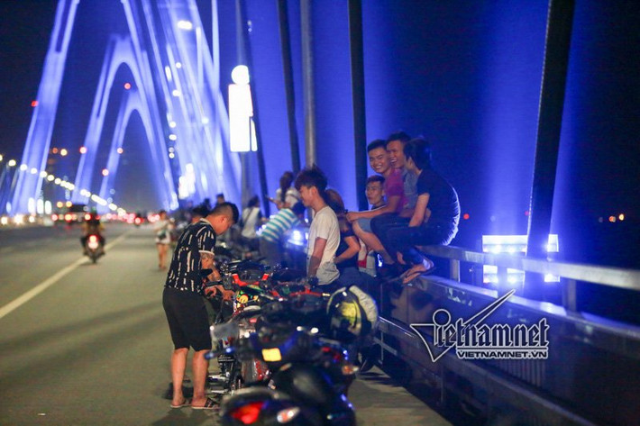 Nhiều bạn trẻ muốn có những kiểu ảnh độc, lạ đã bất chấp nguy hiểm trèo ra ngoài hành lang cầu Nhật Tân để chụp ảnh. Có những đôi bạn leo ra ngoài lan can cầu Nhật Tân ngồi hóng mát. Ảnh: Cầu Nhật Tân - cây cầu hiện đại và đẹp nhất Hà Nội là điểm đến lý tưởng của nhiều bạn trẻ trong những tối hè nắng nóng