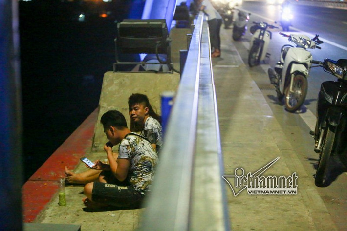 Ngồi bên ngoài hành lang cầu hóng mát như không hề thấy sự nguy hiểm