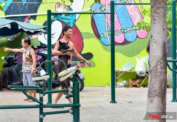 Một người dân hoảng loạn, vội ôm chó của mình chạy vào trong nhà vì sợ vật nuôi của mình bị đội bắt chó đưa đi.