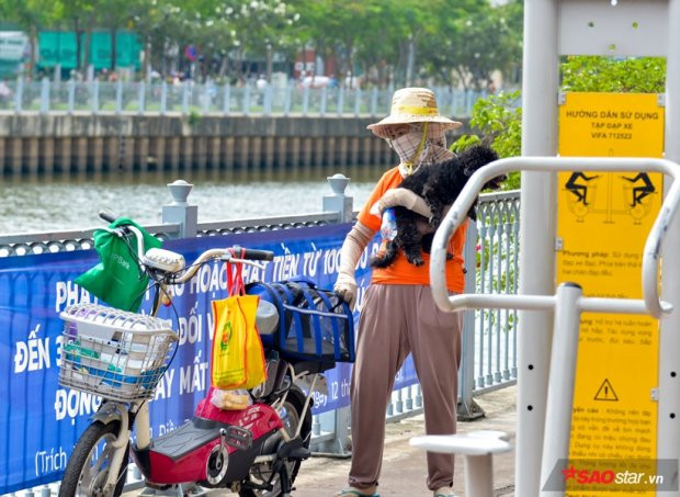 Nhiều người dân đang đưa chó cưng đi dạo trong công viên nhưng không đeo rọ mõm cũng bị lực lượng chức năng nhắc nhở