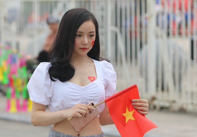 Trong trang phục quyến rũ, mặt dán quốc kỳ và tay cầm lá cờ đỏ sao vàng, hot girl ngủ gật - Thủy tiên hòa vào dòng người để cổ vũ cho Quang Hải và các đồng đội U23 Việt Nam ra sân trận đầu với đối thủ Palestine.