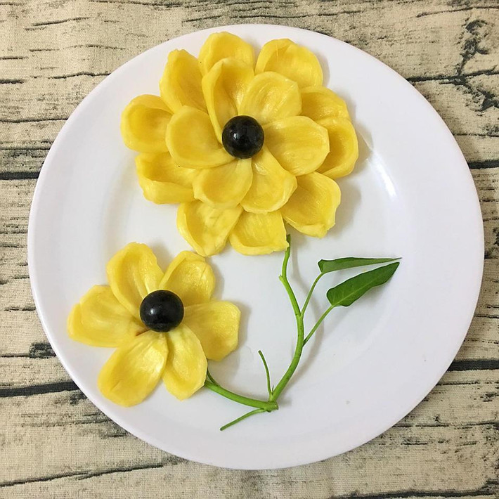 Nếu cảm thấy việc tỉa lá tốn thời gian, hãy chọn ngay một cọng rau muống xinh xắn làm cành. Phần hoa bạn có thể tùy ý sáng tạo với mít, nho đen, mận hoặc xoài.