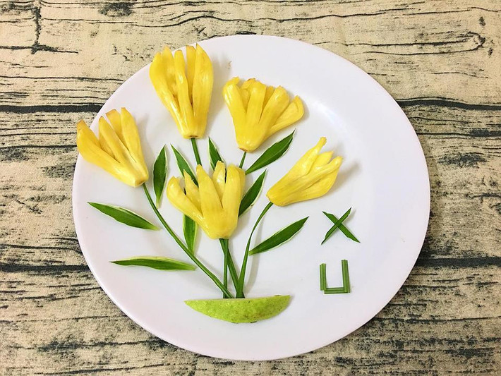 Cầu kỳ hơn một chút, bạn có thể biến mít thành những nhành hoa bằng việc khứa múi mít thành các cánh. Phần lá hoa có thể cắt từ lá ổi và đế hoa là một miếng ổi nhỏ.