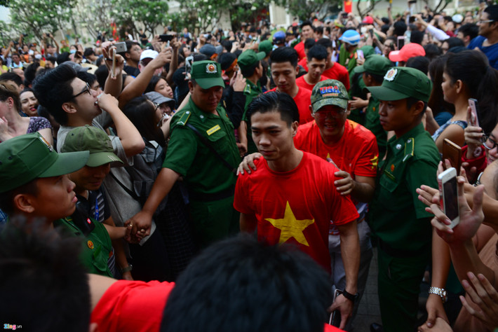 Công Phượng và các tuyển thủ U23 Việt Nam được đưa ra xe một cách nhanh chóng trong vòng vây của NHM. Ảnh: Zing.vn