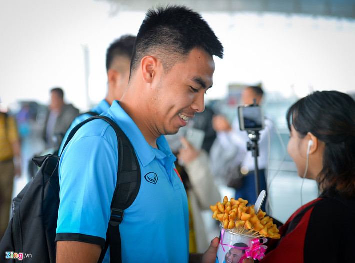 Khi tiền vệ Đức Huy đang đi vào làm thủ tục, thì một fan nữ chạy theo, tặng cho anh món quà đặc biệt đó là hộp bánh gấu.