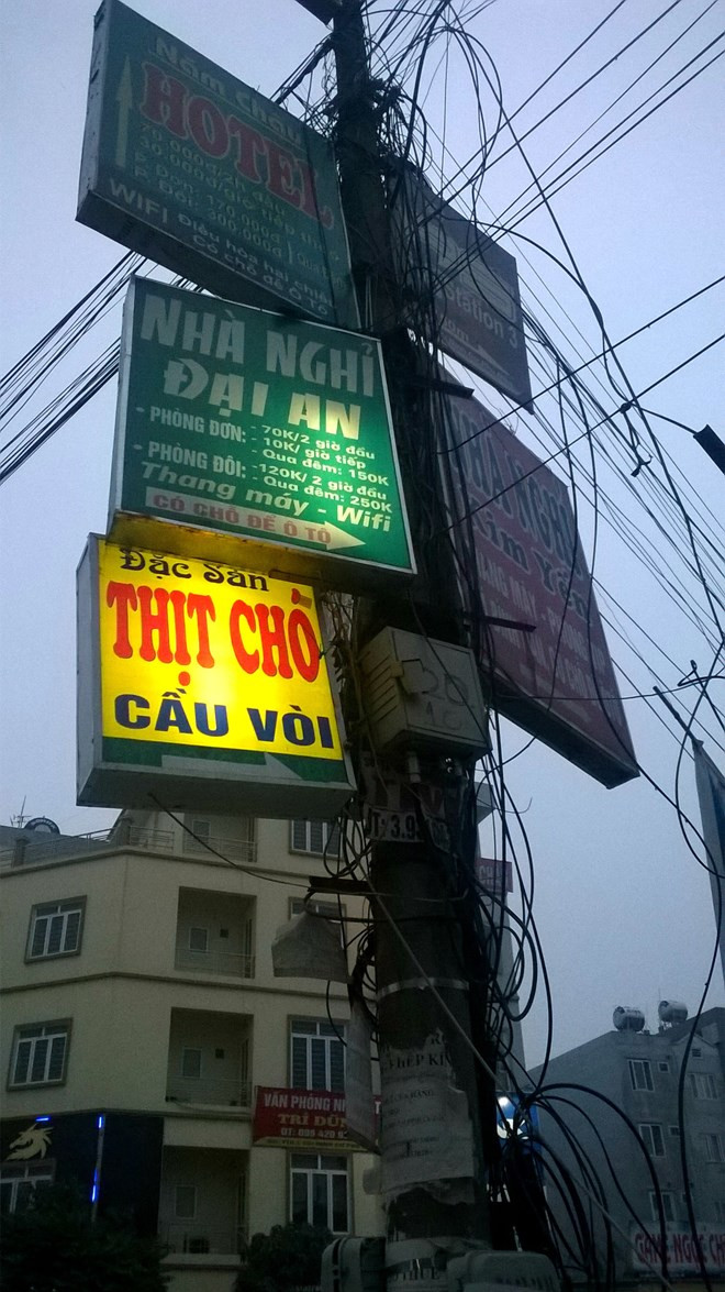 "Rừng" quảng cáo đu bám trên cột điện.