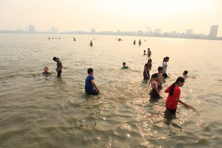 Chiều 19/4, rất nhiều người dân Thủ đô rủ nhau ra bãi tắm ở Hồ Tây để "giải nhiệt", trong đó có rất nhiều em nhỏ cũng xuống tắm mà không có người lớn đi kèm.