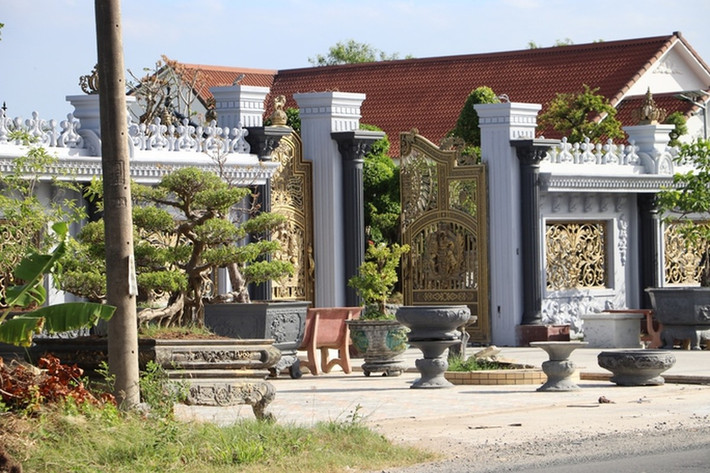 Cổng vào căn biệt thự bề thế với nhiều chậu cây cảnh. Ảnh: Người lao động
