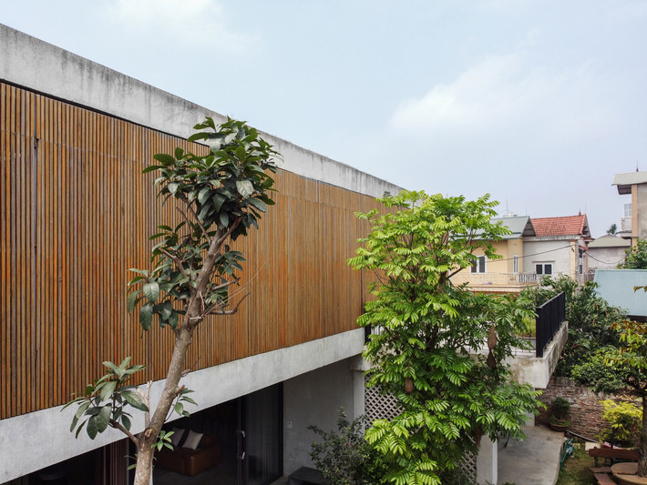 Mặt trước của căn nhà ấn tượng với hệ thống cửa nan tre ép khung sắt có thể đóng mở linh hoạt.
