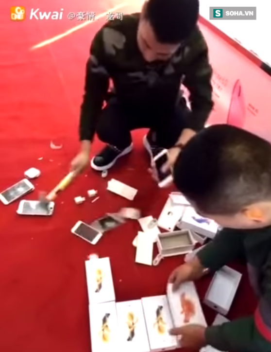 Những chiếc iPhone vỡ nát theo từng nhát búa dưới sàn nhà. Ảnh: Kwai.