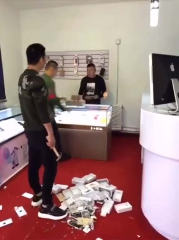 Muốn chứng tỏ mình là người có tiền, một thanh niên Trung Quốc đã "đập hộp" theo đúng nghĩa đen 10 chiếc iPhone mới sau khi thanh toán đủ số tiền cho chủ cửa hàng. Ảnh: Kwai.