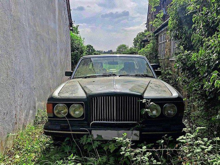 Trong khuôn viên dinh thự còn 4 chiếc xe hơi đắt đỏ và một chiếc Bentley đã gỉ sét. Ảnh: BI