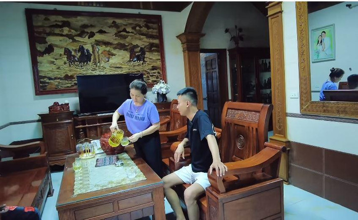 Giữa phòng khách là bộ bàn ghế gỗ sang trọng.