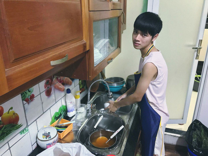 Gương mặt tội nghiệp của một chàng trai bị người yêu bắt vào bếp rửa bát.