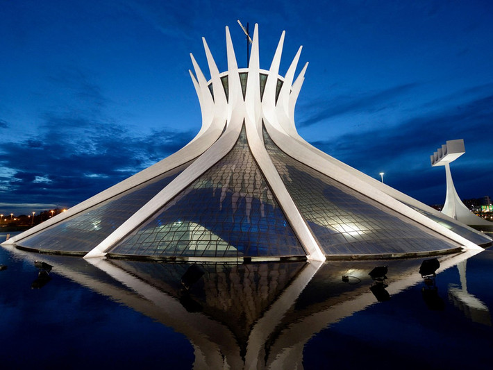 Do kiến trúc sư người Brazil nổi tiếng Oscar Niemeyer thiết kế, nhà thờ Brasilia (Brazil) có cấu trúc như vương miện xuất hiện ghim xuống đất. Nơi đây được tạo thành từ 16 cột bê tông uốn cong giống nhau, kết nối bởi các tấm kính. Thiết kế này tượng trưng cho bàn tay đang vươn lên thiên đường. Mái và khoảng cách giữa các cột bê tông ở đây được phủ đầy kính màu xanh trắng, giúp không gian ngập tràn ánh sáng mặt trời. Ảnh: docomomous.