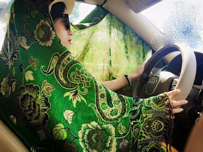 Dù đã ngồi trong ô tô, nhưng người phụ nữ này vẫn cố che chắn cẩn thận trước ánh nắng bên ngoài.