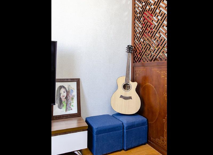 Vách ngăn gỗ giúp ngăn cách không gian phòng khách và bàn thờ. Nữ diễn viên không biết chơi guitar nhưng chuẩn bị sẵn một chiếc đàn để bạn bè đến chơi.