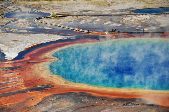 The Grand Prismatic Spring, Wyoming, Mỹ: Suối nước nóng lớn nhất nước Mỹ rộng 113 m được tìm thấy ở Công viên quốc gia Yellowstone. Nó có tên do màu sắc ánh kim rực rỡ, giống như màu sắc của cầu vồng: đỏ, cam, vàng, xanh lá cây và xanh dương. Hiệu quả là do vi khuẩn trong nước tạo thành. Màu sắc của vòng nhẫn này thay đổi mỗi mùa, ngoại trừ trung tâm, không có vi khuẩn do nhiệt độ khắc nghiệt 70 ° C.