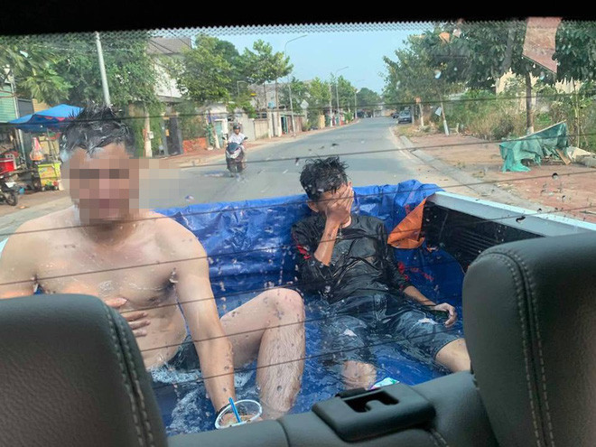 Cụ thể, trời nắng nóng gần 40 độ, 2 nam thanh niên trên chiếc xe bán tải đã nghĩ ra cách đổ nước vào thùng xe. Xe vừa chạy trên đường, họ vừa ung dung trầm mình trong làn nước mát cùng cốc bia.