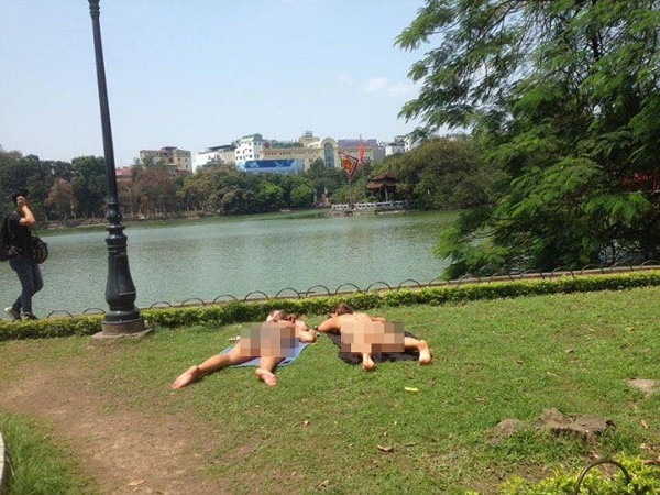 Trước đó, CĐM ghi nhận hình ảnh về cặp đôi du khách nước ngoài cũng phơi nắng phản cảm ngay trên bãi cỏ khu vực hồ Gươm.