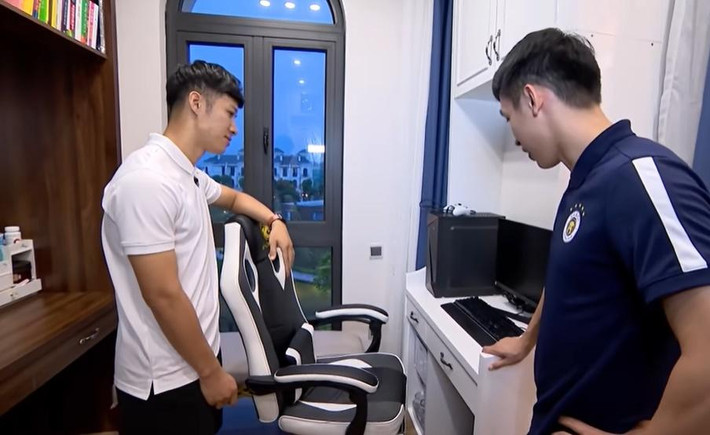 Góc giải trí của Hùng Dũng trong phòng ngủ gồm một bàn máy tính, kệ sách.