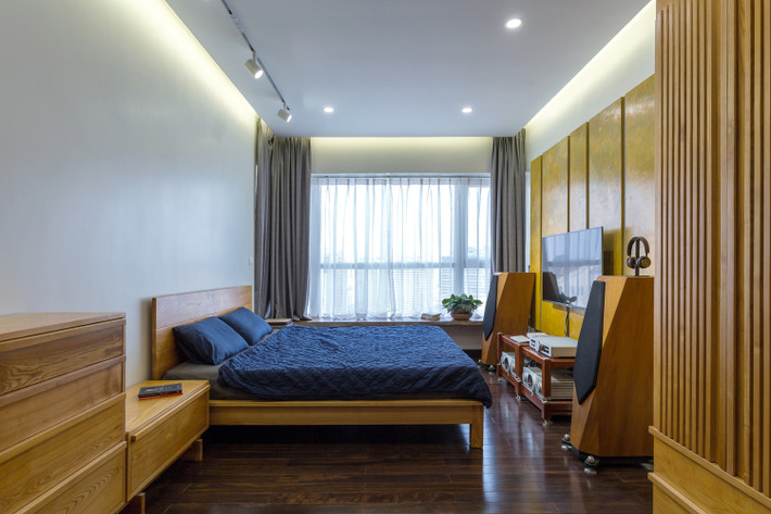 Phòng ngủ bố trí đơn giản, có cửa sổ lớn nhìn ra thành phố.