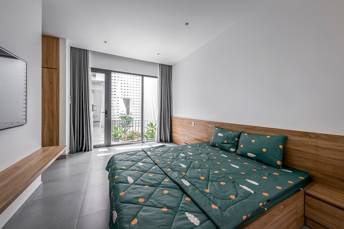 Vách phòng ngủ với mảng kính lớn nhìn ra giếng trời và mảng xanh giúp cho chúng ta thư giãn hơn khi ở trong phòng. Nguồn ảnh: Bùi Minh Quốc