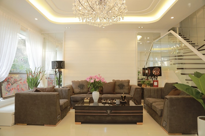 Phòng khách sang trọng với bộ bàn ghế nâu nổi bật trên nền gam màu trắng. Ảnh: 2dep