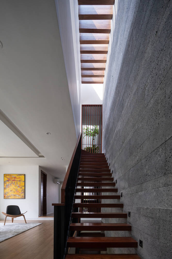 Cầu thang hiện đại nằm dưới giếng trời nên hưởng trọn ánh sáng tự nhiên.