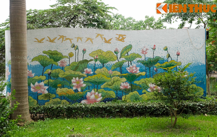 Gần đó, một bức tranh tường cẩn gốm diễn tả đầm sen nở rộ và đàn chim sải cánh bay vô cùng đẹp mắt.