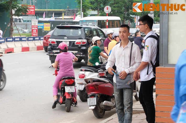 Hai sĩ tử tranh thủ trao đổi thông tin ngoài cổng trường.