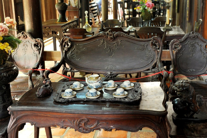 Bàn và sập trong căn nhà cổ cũng đều là gỗ quý nguyên tấm đen bóng. Các bộ ghế được chế tác kỳ công. Ảnh: Mia