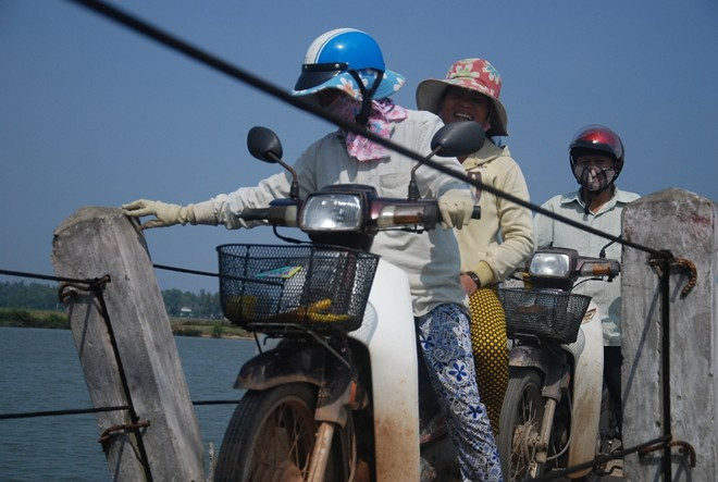Vẫn biết rất nguy hiểm nhưng do giao thông nối 2 xã Tam Tiến và Tam Xuân 2 rất khó khăn nên người dân liều mình qua cầu. Họ phải chạy xe rất chậm, một tay vịn vào lan can.