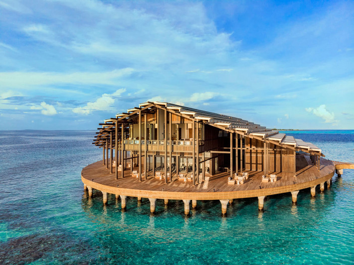 Khu nghỉ bao gồm 15 bungalows uốn cong trên mặt nước theo hình tròn.