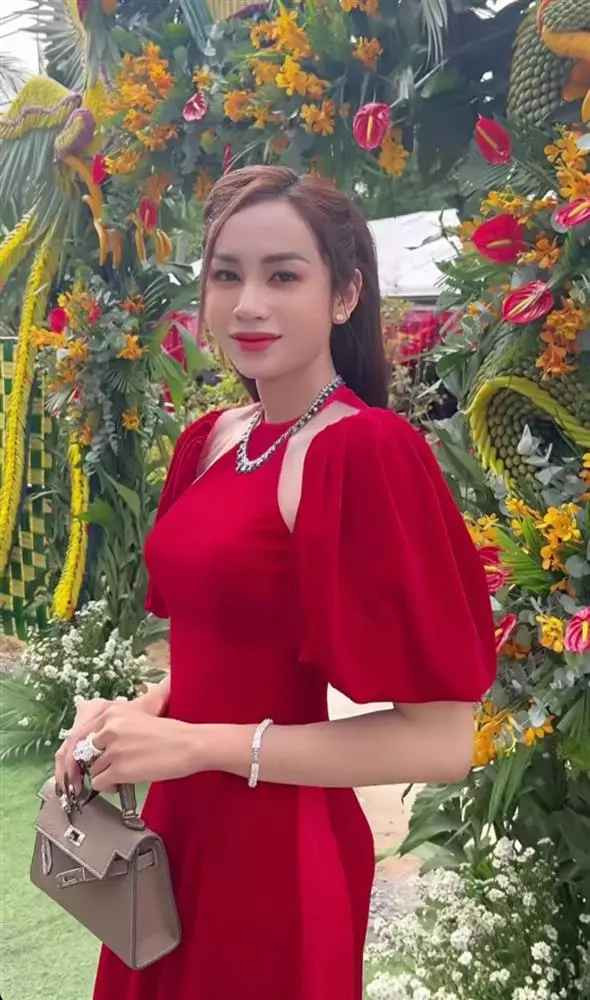Lương Mỹ Kỳ diện chiếc áo dài cách tân cut-out màu đỏ nổi bật, kết hợp túi Hermès đắt đỏ cùng hàng loạt trang sức từ vòng cổ, vòng tay đến nhẫn.