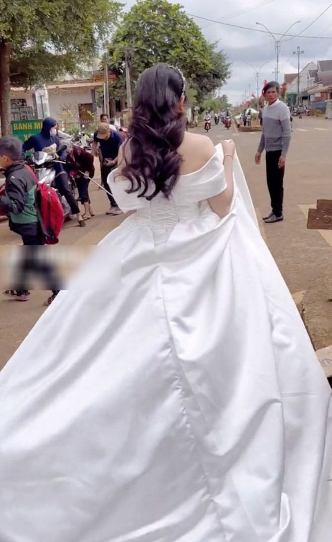 Mới đây, đoạn clip ghi lại cảnh cô dâu đang mặc trên mình một bộ váy cưới rất dài và nặng nhưng vẫn sẵn sàng xách váy, chạy một đoạn đường ngắn để ra gặp shipper để nhận hàng thu hút sự chú ý của nhiều người.