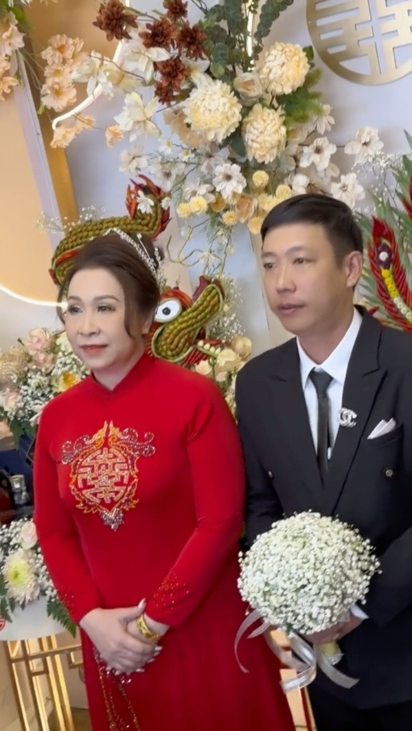 Qua đoạn video ghi lại cảnh đám cưới, có thể thấy cô dâu và chú rể đang tiến hành nghi lễ nhận quà từ người thân trong gia đình. Cặp vợ chồng diện trang phục cưới truyền thống, cô dâu mặc áo dài đỏ, chú rể diện vest vô cùng lịch lãm.