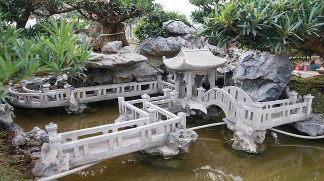 Nhìn từ xa, 7 cây tùng được đặt trong tiểu cảnh gồm đá, hồ nước nhân tạo kết hợp với đèn điện và các chi tiết nhỏ xung quanh. Ảnh: Dân trí