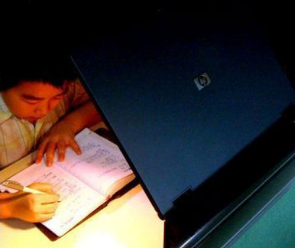 Tận dụng ánh sáng của laptop làm đèn học cho con trong lúc cần thiết. Ảnh: Loffee.