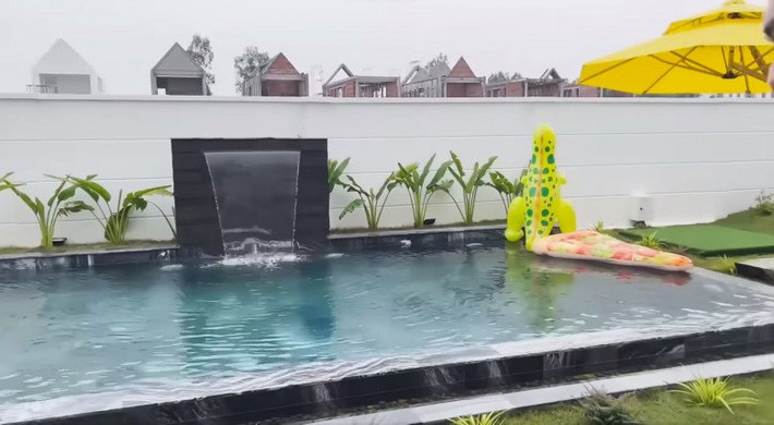 Bể bơi có thác nước, cây xanh tạo cảnh quan độc đáo.