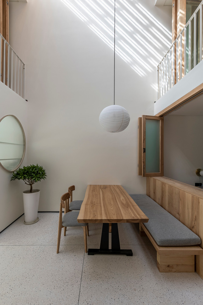 Sàn terrazzo làm giảm cảm giác “tĩnh” của căn nhà đơn sắc, thêm chút nhịp điệu từ những bức tranh treo tường và những đường vân màu tự nhiên của gỗ tần bì; cảm giác mang lại từ bề mặt chất liệu phải phù hợp với lối sống tối giản của gia chủ.