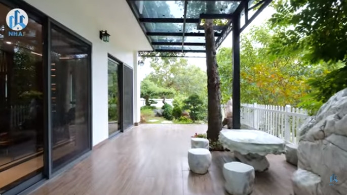 Phía sau nhà là khoảng sân vườn thoáng đãng, có bộ bàn ghế bằng đá nguyên khối để gia chủ thưởng trà, thư giãn...