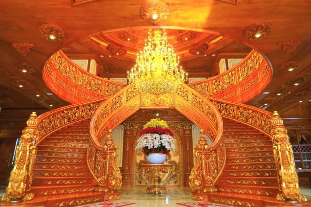 Cầu thang gỗ uốn lượn tại sảnh chính được coi là điểm nhấn của căn nhà.
