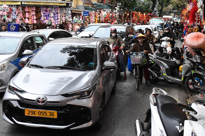 Phố Hàng Mã cũng trong tình cảnh tương tự khi rất đông người mua sắm đồ trang trí Tết. Mỗi khi có một chiếc ô tô di chuyển qua, tình trạng ùn tắc lại diễn ra.