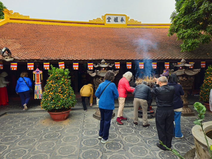 Du khách nước ngoài cũng dâng hương khi tiến vào thăm quan chùa Trấn Quốc trong sáng mùng 1 Tết.