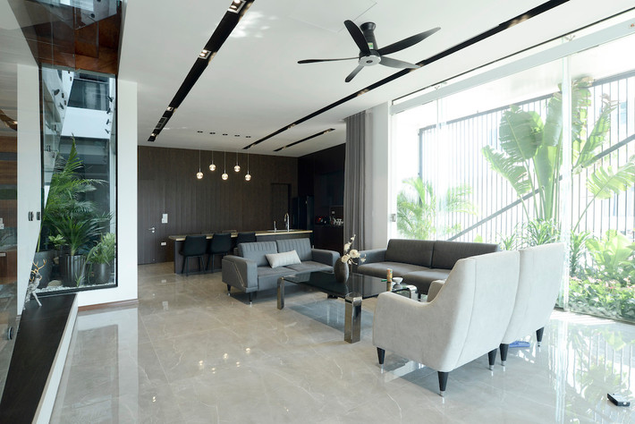 Bên phía hướng Tây, các khoảng lùi nhỏ như sân ướt, cây xanh khiến không gian chức năng bên trong không bị ảnh hưởng bởi nắng gắt. Với cách bố trí như vậy, không gian phòng khách sẽ đón được những ánh nắng hoàng hôn cuối chiều qua những tán lá.